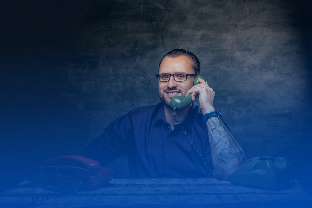 Profissional de terno segurando um aparelho de telefone antigo com fio, representando as limitações da telefonia convencional frente às novas tecnologias em nuvem.
